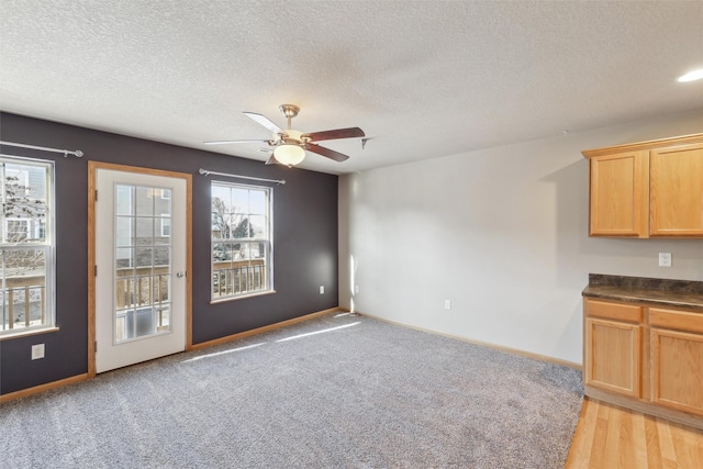 carpeted spare room featuring a textured ceiling and ceiling fan