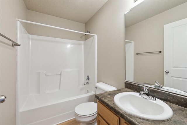 full bathroom with toilet, vanity, a textured ceiling, and bathing tub / shower combination