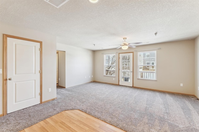 spare room featuring ceiling fan, a textured ceiling, visible vents, and wood finished floors