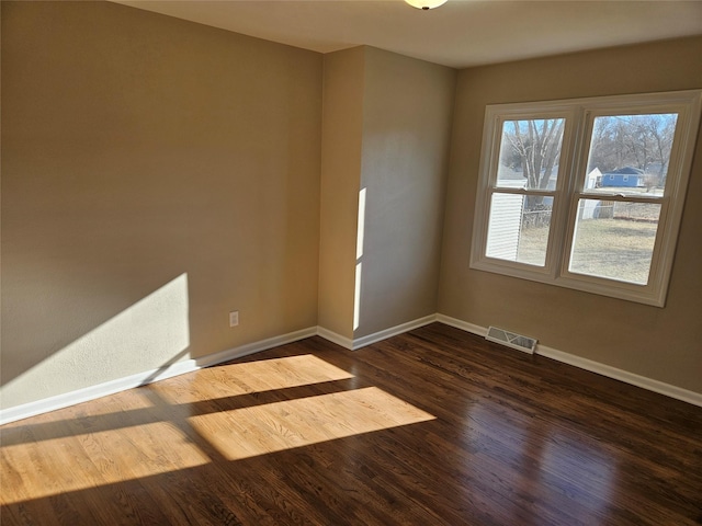 spare room with dark hardwood / wood-style flooring