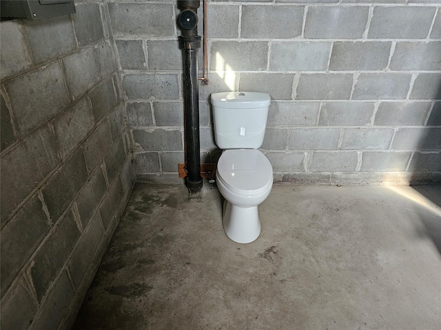 bathroom with concrete flooring and toilet