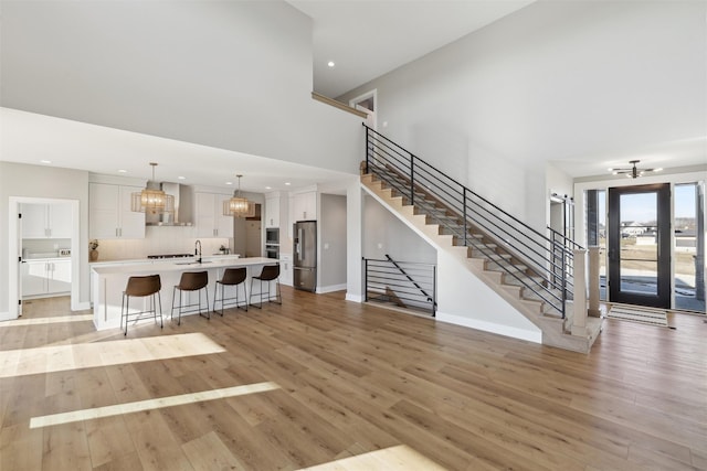 18256 Alderleaf Dr, Clive, IA 50325 - living area with a high ceiling, stairway, light wood-type flooring, recessed lighting, and a chandelier