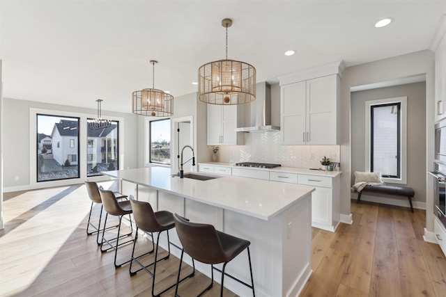 18256 Alderleaf Dr, Clive, IA 50325 - kitchen featuring a sink, a chandelier, wall chimney range hood, light countertops, and decorative backsplash