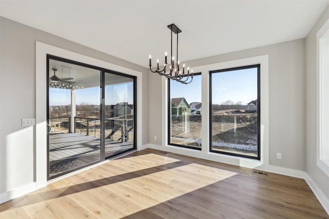 18256 Alderleaf Dr, Clive, IA 50325 - unfurnished dining area with baseboards, a notable chandelier, wood finished floors, and visible vents