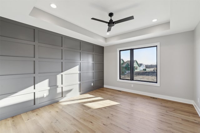 18256 Alderleaf Dr, Clive, IA 50325 - unfurnished bedroom featuring baseboards, a raised ceiling, and light wood-style floors