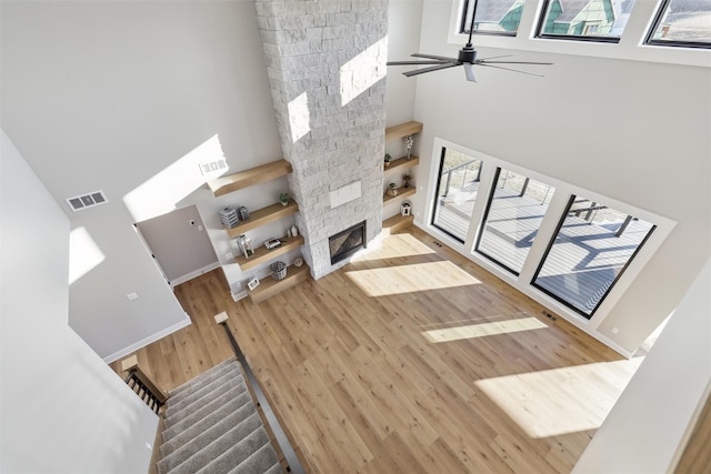 18256 Alderleaf Dr, Clive, IA 50325 - unfurnished living room featuring visible vents, a fireplace, wood finished floors, and a towering ceiling