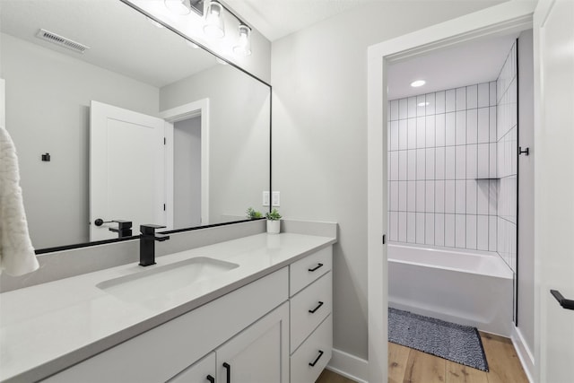 18256 Alderleaf Dr, Clive, IA 50325 - full bathroom featuring baseboards, vanity, wood finished floors, and visible vents