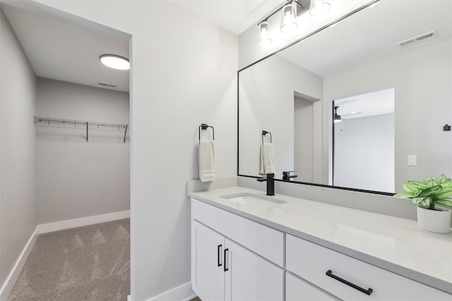 18256 Alderleaf Dr, Clive, IA 50325 - bathroom with vanity, baseboards, a walk in closet, and visible vents