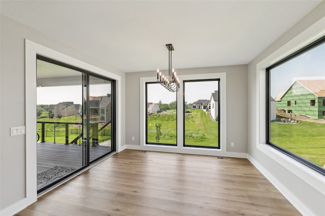 18256 Alderleaf Dr, Clive, IA 50325 - unfurnished dining area featuring plenty of natural light, a chandelier, and light wood-style floors