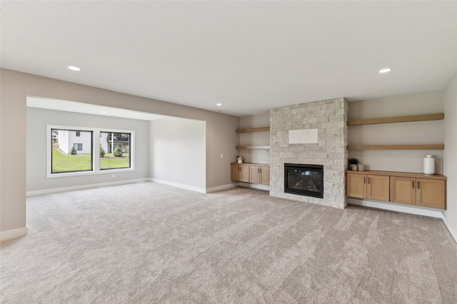 18256 Alderleaf Dr, Clive, IA 50325 - unfurnished living room featuring light colored carpet, baseboards, a stone fireplace, and recessed lighting
