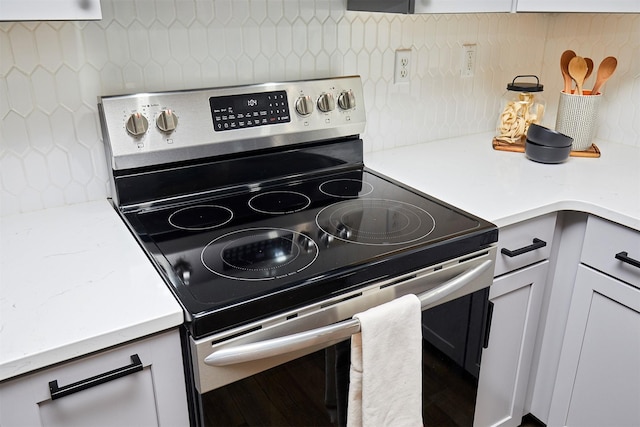 kitchen with backsplash and stainless steel electric range oven