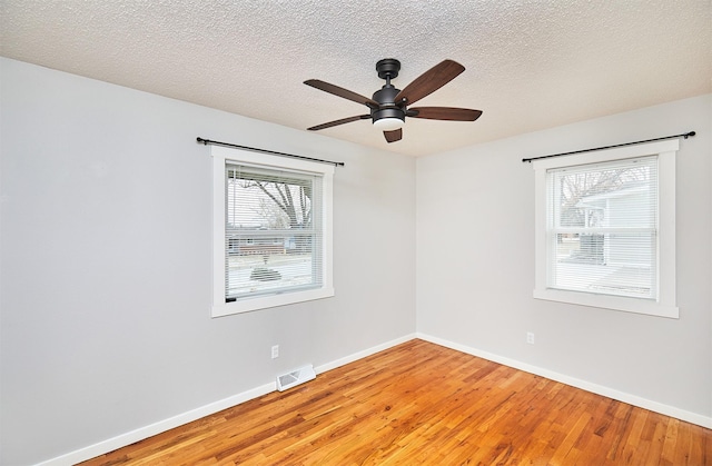 spare room with ceiling fan, a textured ceiling, and wood-type flooring