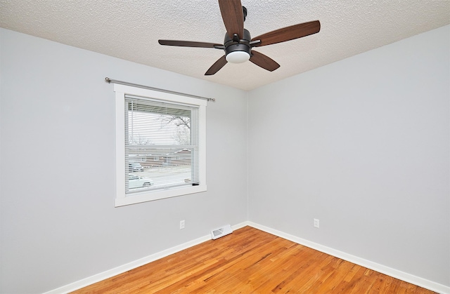 spare room featuring a textured ceiling, ceiling fan, and wood-type flooring