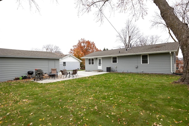 rear view of property with a yard, central air condition unit, and a patio area