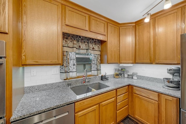 kitchen with light stone countertops, appliances with stainless steel finishes, backsplash, and sink