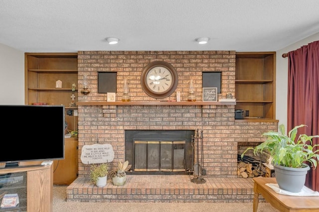 living room featuring a brick fireplace, a textured ceiling, built in shelves, and carpet