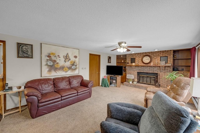 carpeted living room featuring a fireplace, ceiling fan, a textured ceiling, and built in features