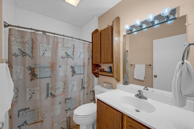 bathroom featuring toilet, a shower with shower curtain, and vanity