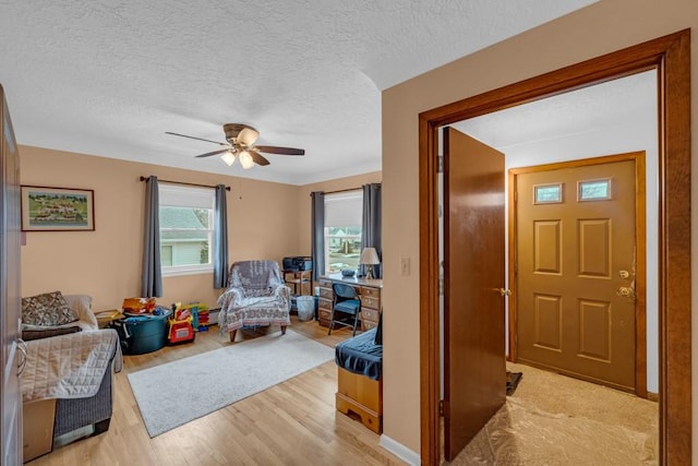 sitting room featuring a textured ceiling, ceiling fan, and light hardwood / wood-style floors