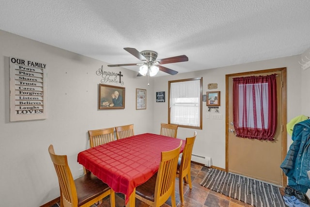 dining area with ceiling fan, baseboard heating, and a textured ceiling