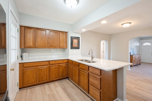 kitchen featuring sink, light hardwood / wood-style floors, and kitchen peninsula