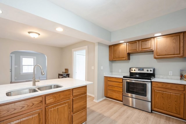 kitchen featuring stainless steel range with electric cooktop, light hardwood / wood-style floors, and sink