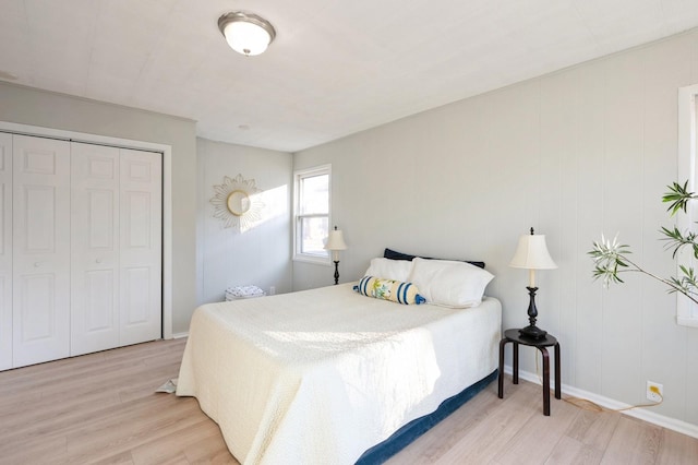 bedroom with light hardwood / wood-style floors and a closet