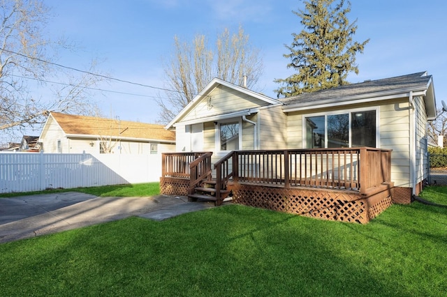 rear view of house featuring a yard and a wooden deck