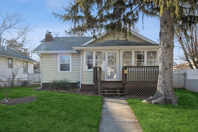 bungalow-style house with a front yard and a sunroom