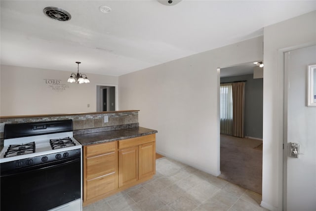 kitchen with gas range, a notable chandelier, decorative light fixtures, and light brown cabinets