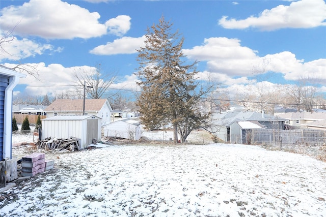 yard layered in snow with a shed