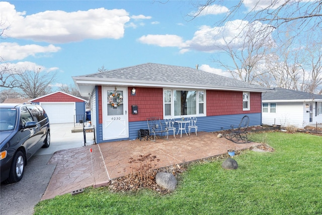 single story home featuring a patio area, a front yard, a garage, and an outdoor structure