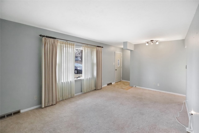 unfurnished room featuring light carpet