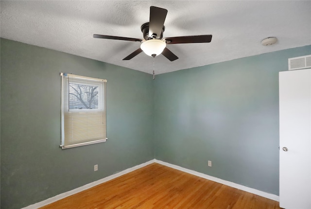 empty room featuring a textured ceiling, ceiling fan, and hardwood / wood-style flooring