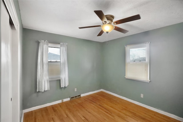 spare room with hardwood / wood-style flooring, a textured ceiling, and ceiling fan