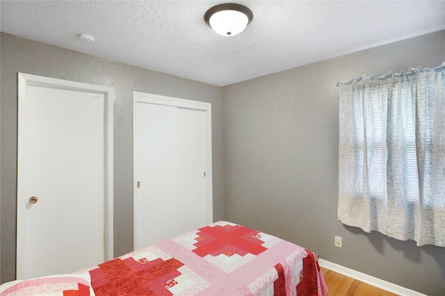 bedroom featuring hardwood / wood-style flooring and a textured ceiling