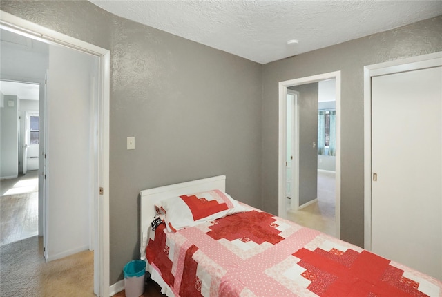 bedroom featuring light colored carpet and a textured ceiling