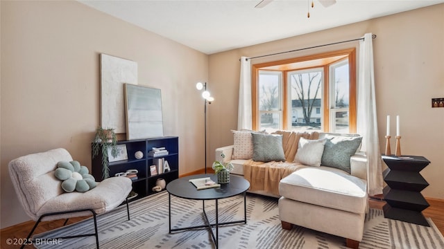 sitting room with ceiling fan and wood-type flooring