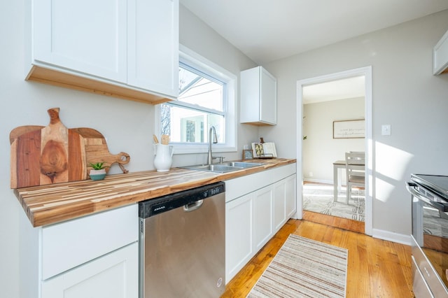 kitchen featuring stainless steel appliances, wooden counters, light wood-type flooring, white cabinetry, and sink