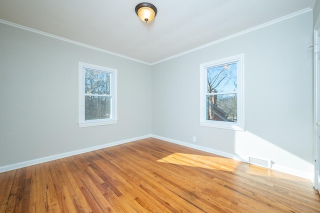 spare room featuring crown molding and light hardwood / wood-style flooring