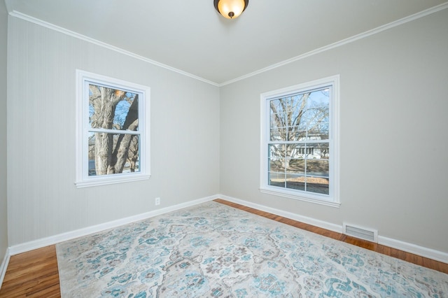 spare room with ornamental molding and wood-type flooring