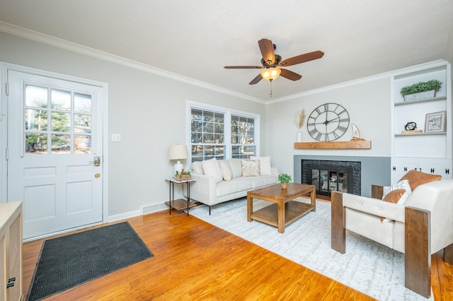 living room with ornamental molding, ceiling fan, and hardwood / wood-style flooring