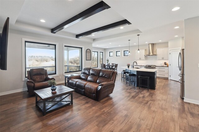 living room with sink, beam ceiling, and dark hardwood / wood-style floors