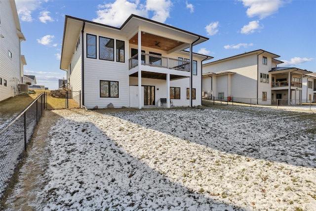 snow covered house with central air condition unit and ceiling fan