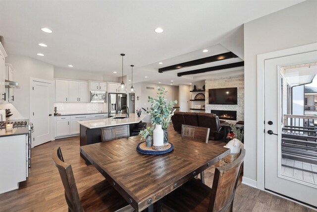 dining area featuring sink, dark hardwood / wood-style flooring, and a fireplace