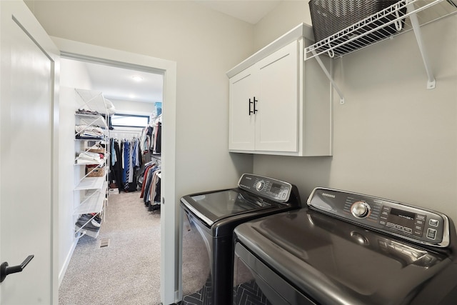 laundry area with carpet flooring, cabinets, and washer and clothes dryer