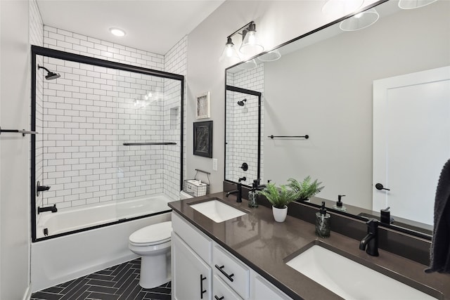 full bathroom featuring bath / shower combo with glass door, vanity, and toilet