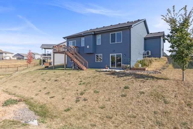 back of property featuring a lawn and a deck