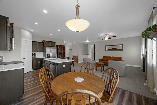 dining area with ceiling fan, dark hardwood / wood-style floors, and sink