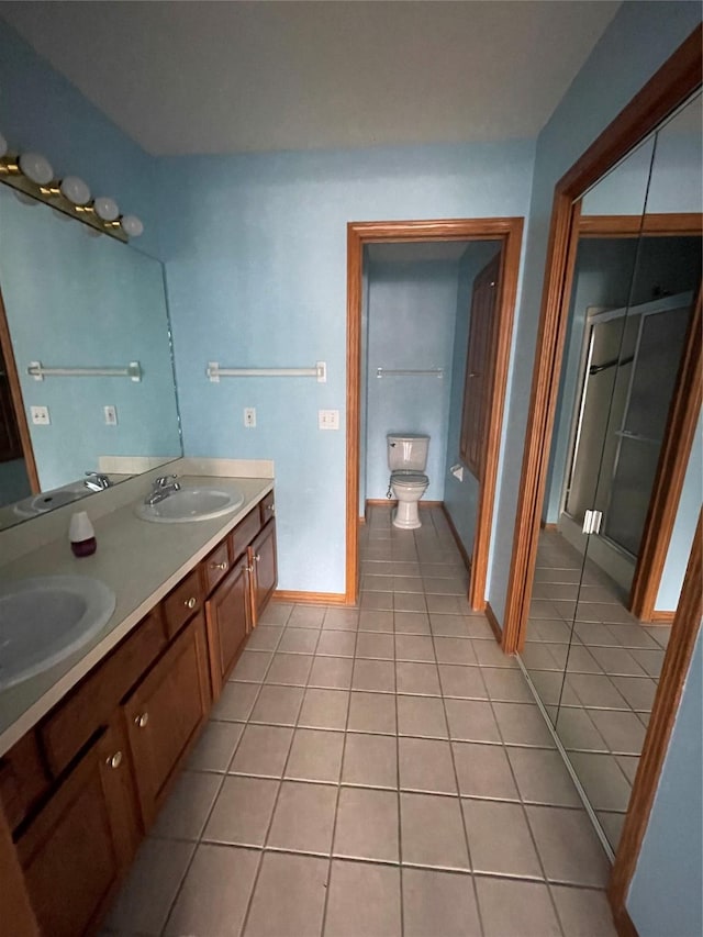 bathroom with toilet, vanity, and tile patterned floors